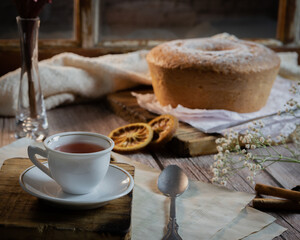 Mesa de madeira com xicara de chá e bolo de laranja