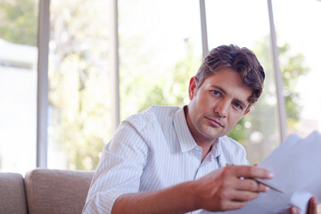 Man reading newspaper on sofa