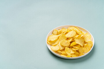 Golden crumbling chips on white plate. copy space.