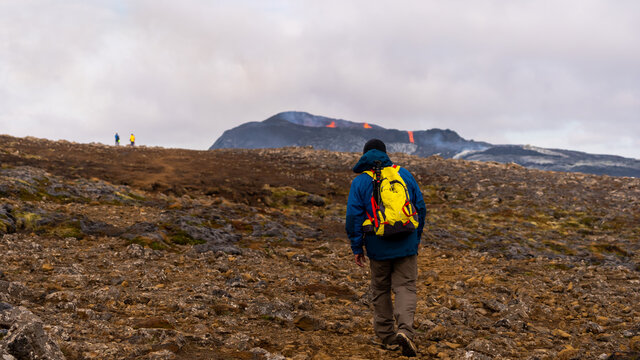 Impressive View Of An Explorer Watching The Exploding Red  Lava  From The Active Volcano In Iceland