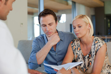 Financial advisor talking to couple on sofa