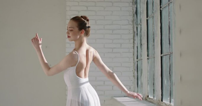 Slender attractive caucasian girl dancing ballet. Young talented choreographer practicing dance moves. Beautiful ballerina demonstrating her skills 4k footage