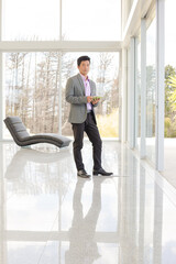 Businessman using tablet computer at window