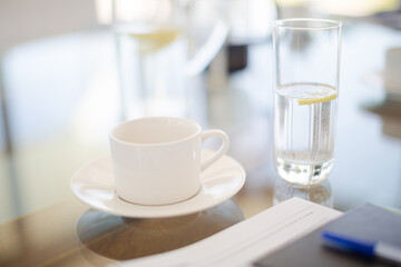 Coffee cup and water glass on meeting table