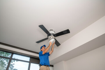 Handyman removing light cover on fan