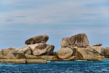 Fototapeta premium small rocks at the open sea in cloudy sky summer day with empty copy space