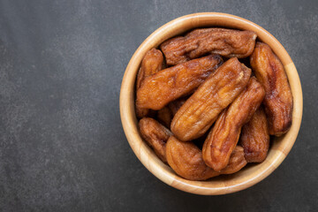 Top view of sun dried bananas in the bowl on black background, Thai dessert