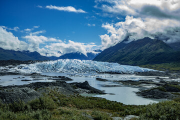beautiful view on melting glacier blue ice with mountains around