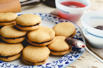 Homemade cookies with marmalade or fruit plum jam in a plate - close up front view baked sweet food traditional recipe - healthy eating concept