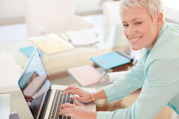 Businesswoman using laptop at desk