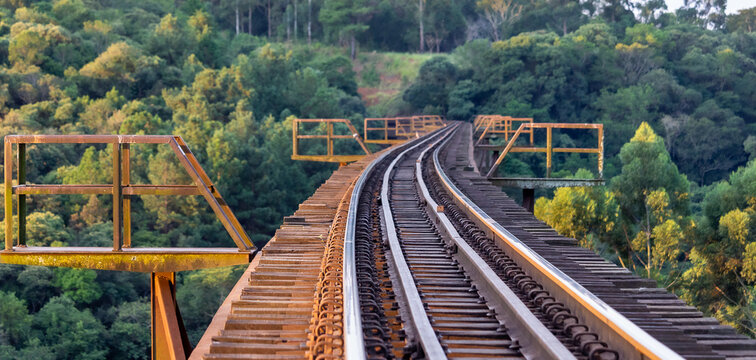 train track over a bridge with trees in the background