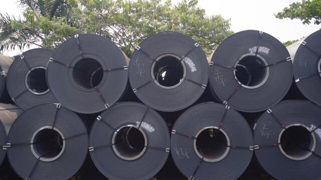Large metal rolls, outdoors at the Goa Port, in sunny India - tracking shot