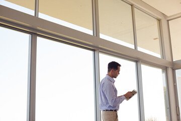 Businessman using tablet computer at window