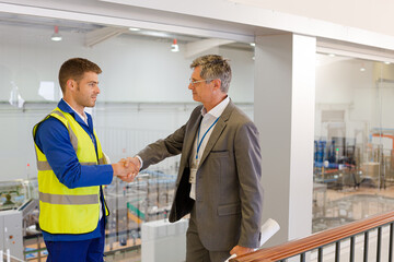 Fototapeta premium Supervisor and worker shaking hands in factory