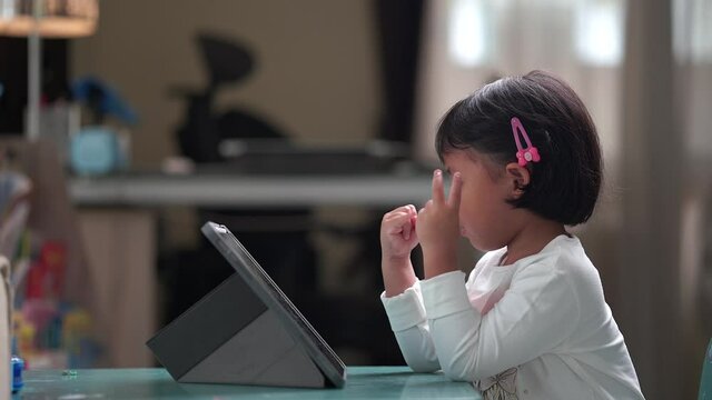 Cute small girl learning mathematics online