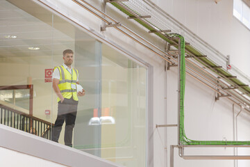 Fototapeta premium Worker looking out glass window in warehouse