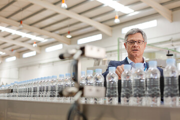 Supervisor examining bottles in factory