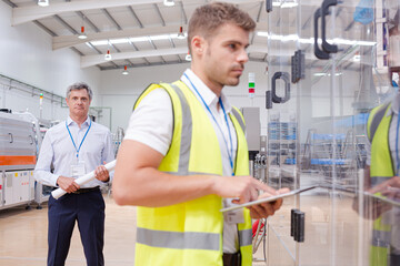 Supervisor watching worker in factory