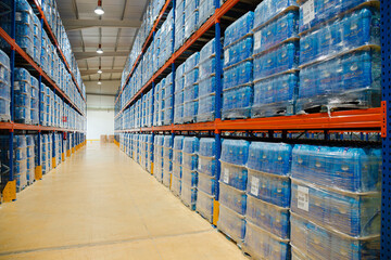 Pallets of water bottles on warehouse shelves
