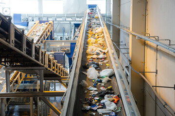Recycled material on conveyor belt in recycling center - obrazy, fototapety, plakaty