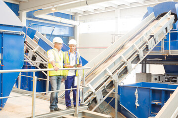 Workers standing on platform in recycling center