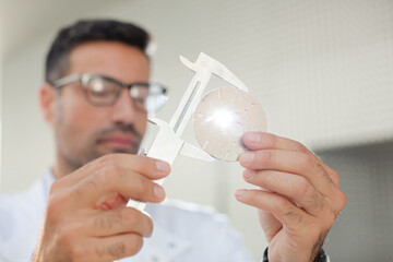 Scientist using caliper