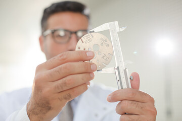 Scientist using caliper