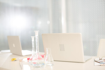 Close up of laptop and  beakers at desk