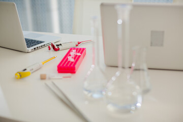 Close up of laptop and  beakers at desk
