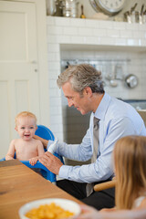 Obraz premium Father and children eating breakfast in kitchen