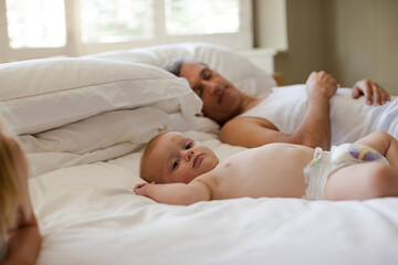 Father and baby laying on bed