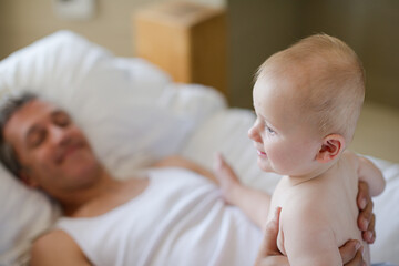 Father and baby relaxing on bed