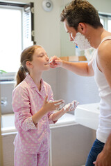 Father and daughter playing with shaving cream