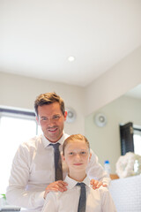 Obraz premium Father and daughter tying ties in bathroom
