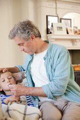 Father checking son's temperature
