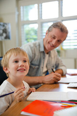 Father and son working in home office