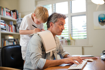 Fototapeta premium Boy hugging working father