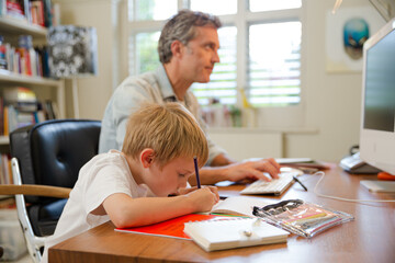 Father and son working in home office