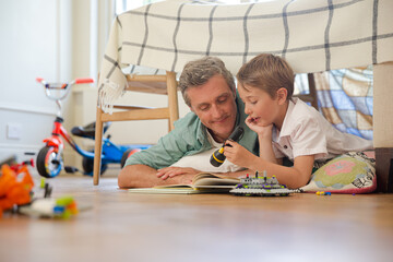 Father and son reading in bedroom