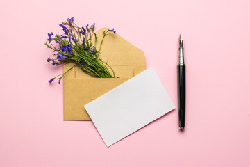 An envelope, a sheet of paper, a fountain pen and a bouquet of flowers on a pink background. Flat...