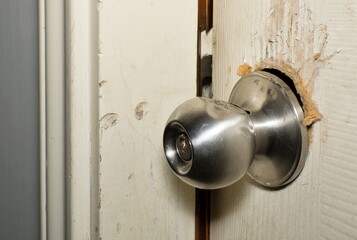 Broken doorknob closeup forced entry crime criminal break in burglar theft robbery home insurance concept.