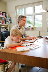 Father and son working in home office