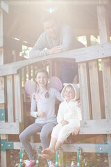 Father and children playing on playset