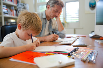 Father and son working in home office