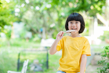 Fototapeta premium asian girl eating ice cream with blur background