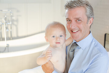 Father holding baby in bathroom