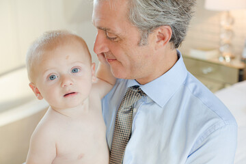 Father holding baby in bathroom