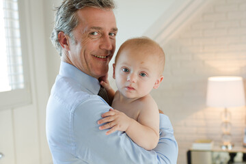 Father holding baby in bathroom