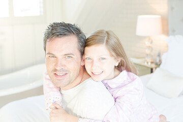 Father and daughter hugging in bedroom