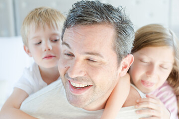 Fototapeta premium Father and children hugging in bedroom
